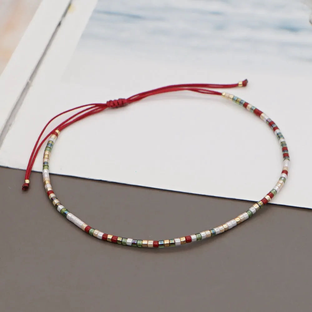 Handmade bohemian-style bracelet with semi-precious stone and colourful glass beads on a wrist.