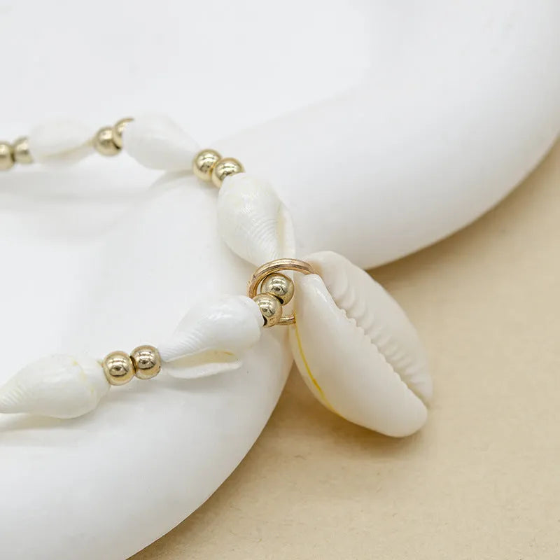 White conch shell bead necklace with mother of pearl pendant on a silver-toned electroplated chain.