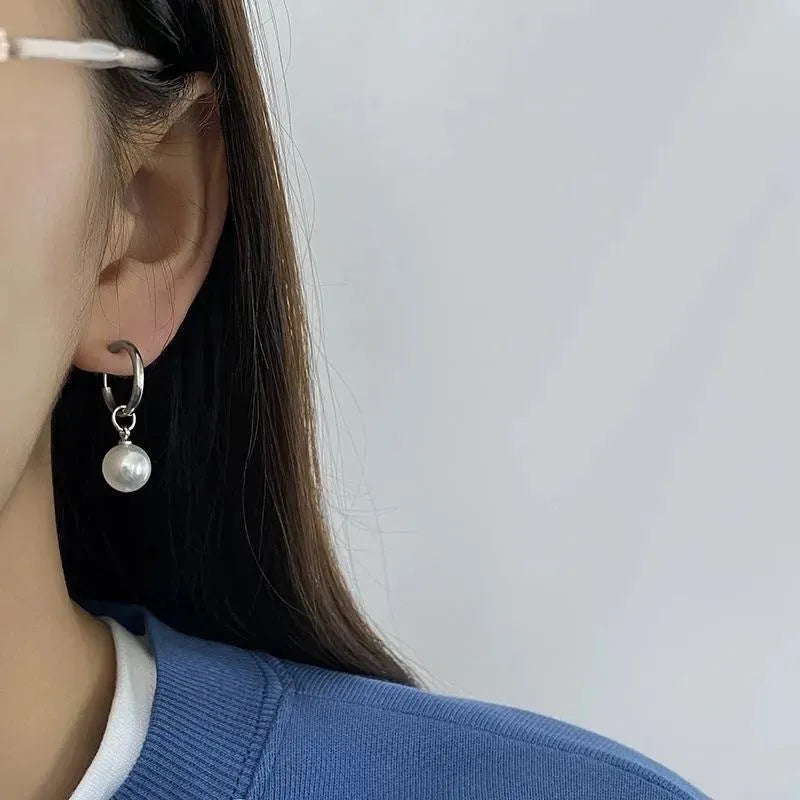 A pair of geometric-shaped women's alloy earrings with a round pearl charm, featuring titanium steel posts.