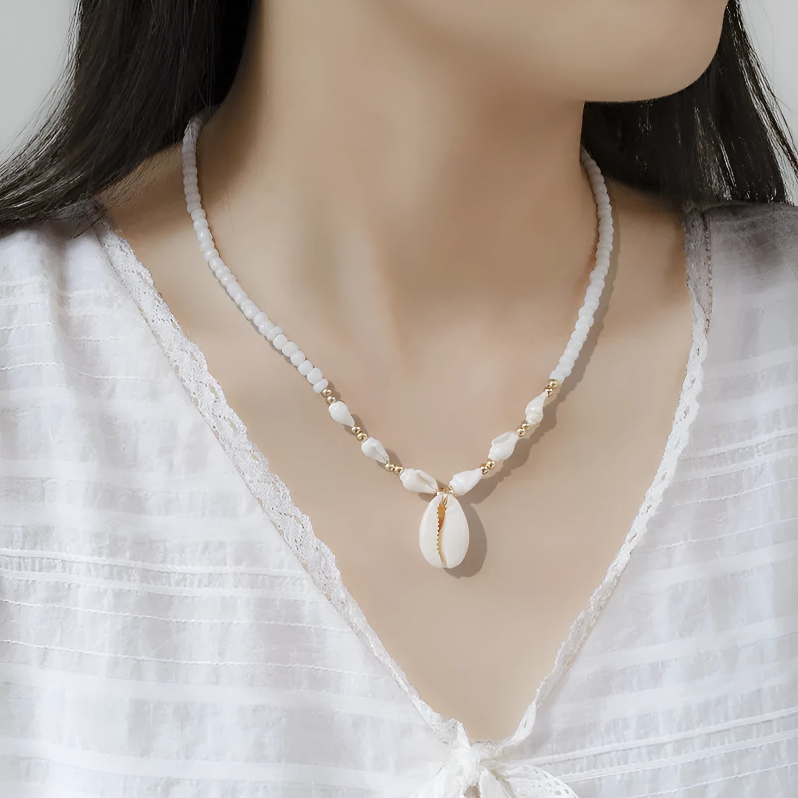 White conch shell bead necklace with mother of pearl pendant on a silver-toned electroplated chain.