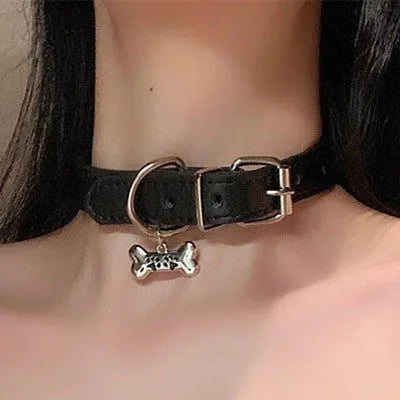 Black leather adjustable dog collar with a small bell charm, shown in cat's paw, bone, and plain design variants.