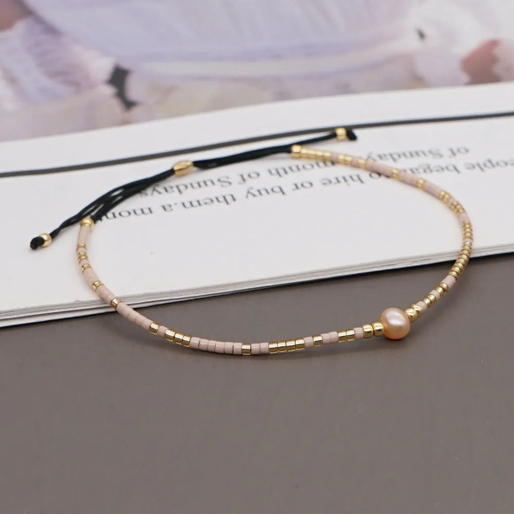 Handmade bohemian-style bracelet with semi-precious stone and colourful glass beads on a wrist.