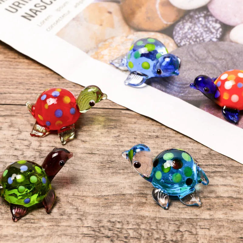Geometric glass turtle ornament with a blue head and blue shell on a wooden desktop.