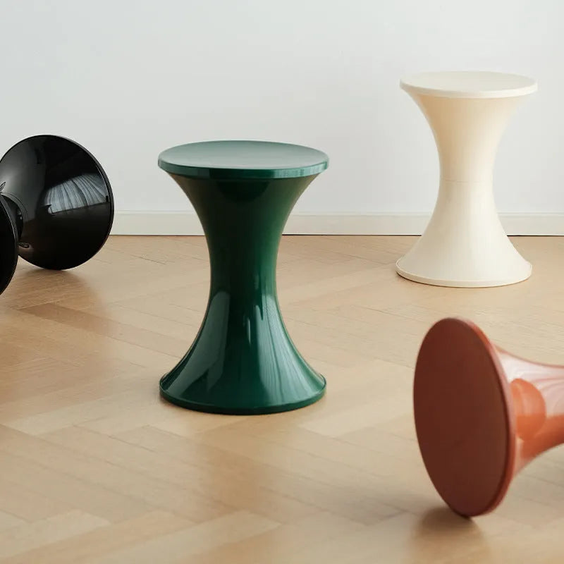 Green hourglass-shaped plastic stool for changing shoes, suitable for children and adults.