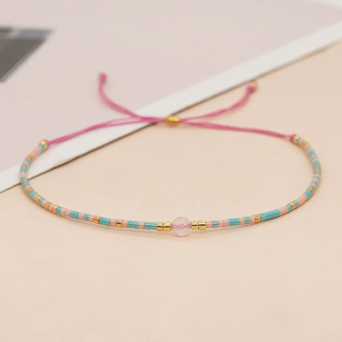 Handmade bohemian-style bracelet with semi-precious stone and colourful glass beads on a wrist.