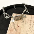 Dark electroplated multi-layer cross necklace with twin clavicle chains on display