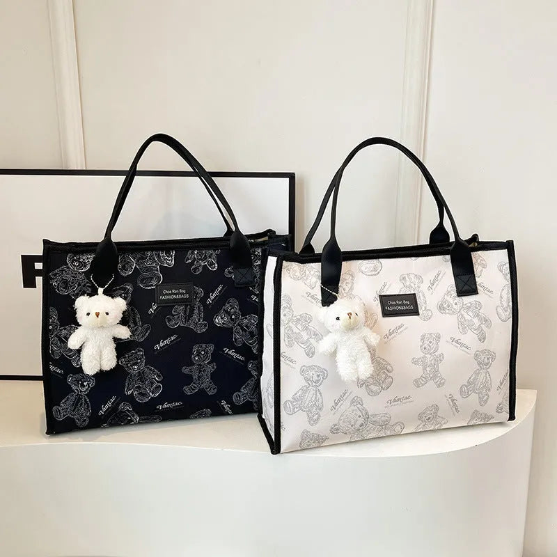 Women's black canvas tote bag with diamond pattern and shoulder strap