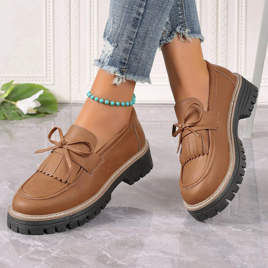 Black plus size women's loafers with tassel decoration, bowknot detail, and chunky rubber sole