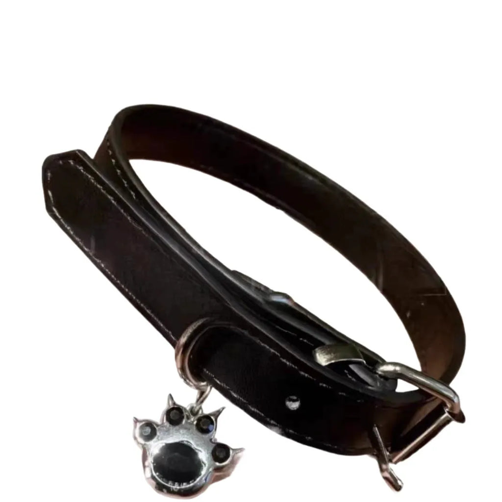 Black leather adjustable dog collar with a small bell charm, shown in cat's paw, bone, and plain design variants.
