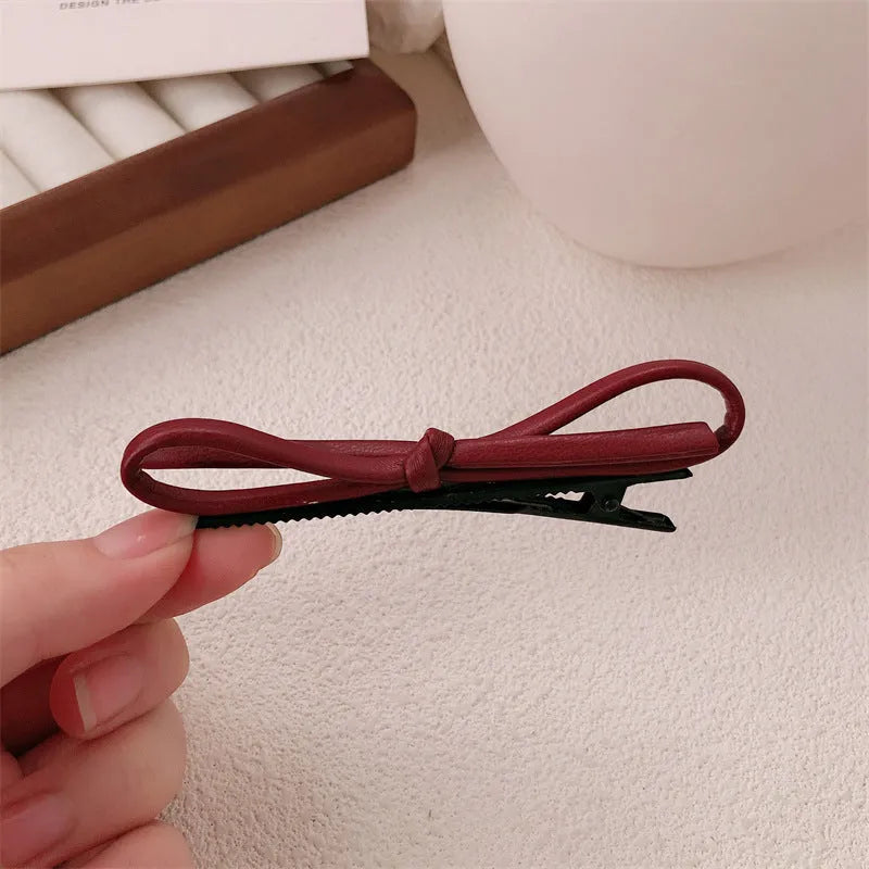 Wine red leather bow barrettes hair clips showing bow design and leather material