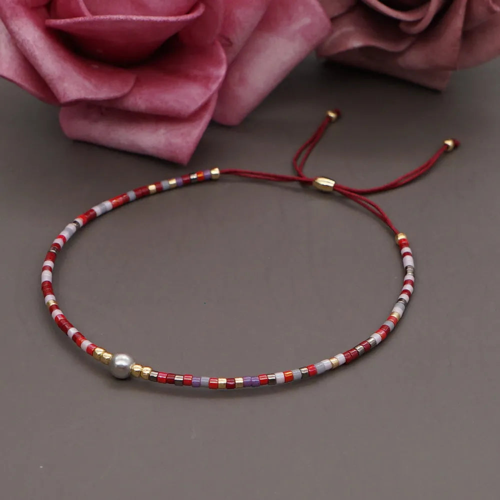 Handmade bohemian-style bracelet with semi-precious stone and colourful glass beads on a wrist.