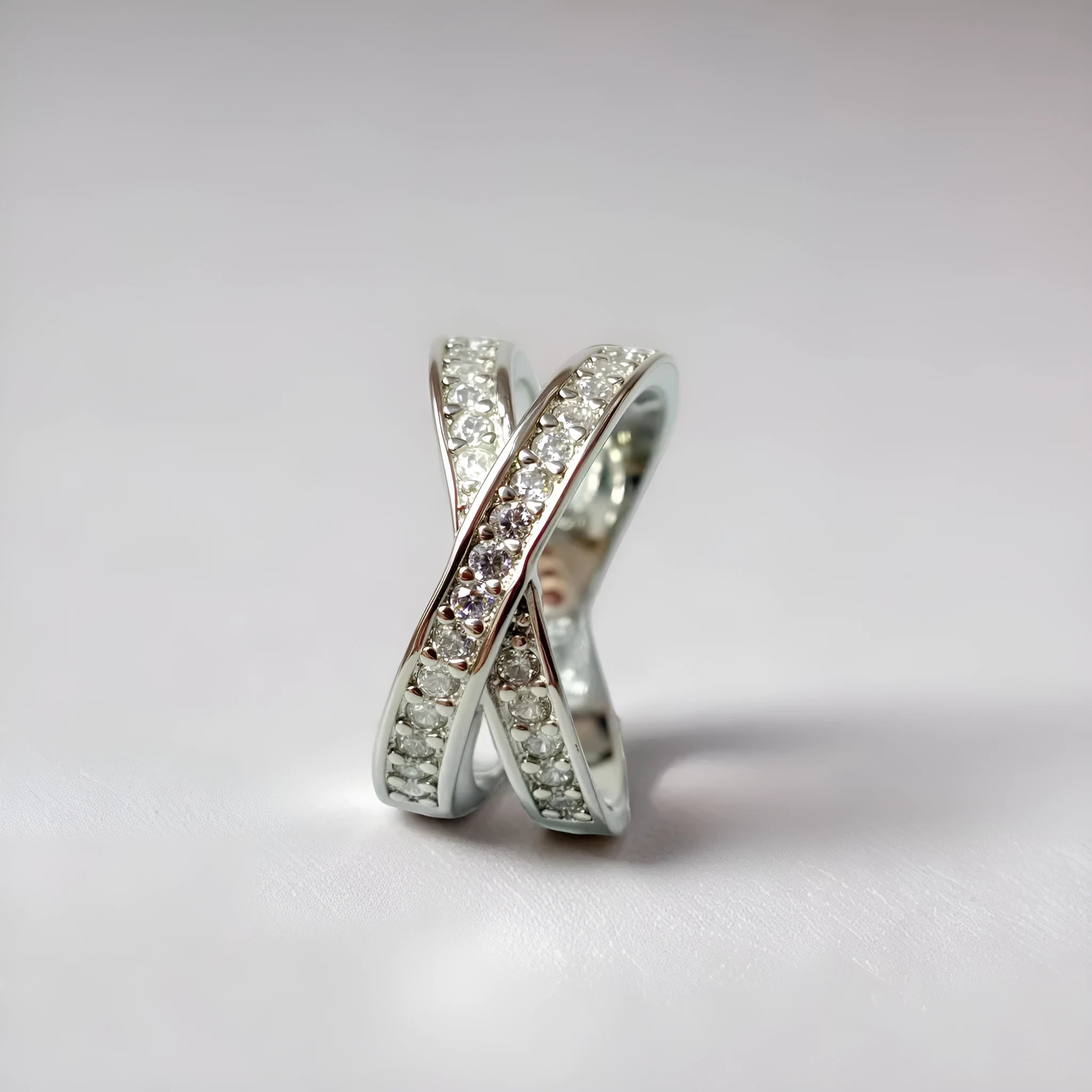 Geometric heart-shaped cross ring with micro-inlaid zircon on a copper base with silver or rose gold electroplated finish.