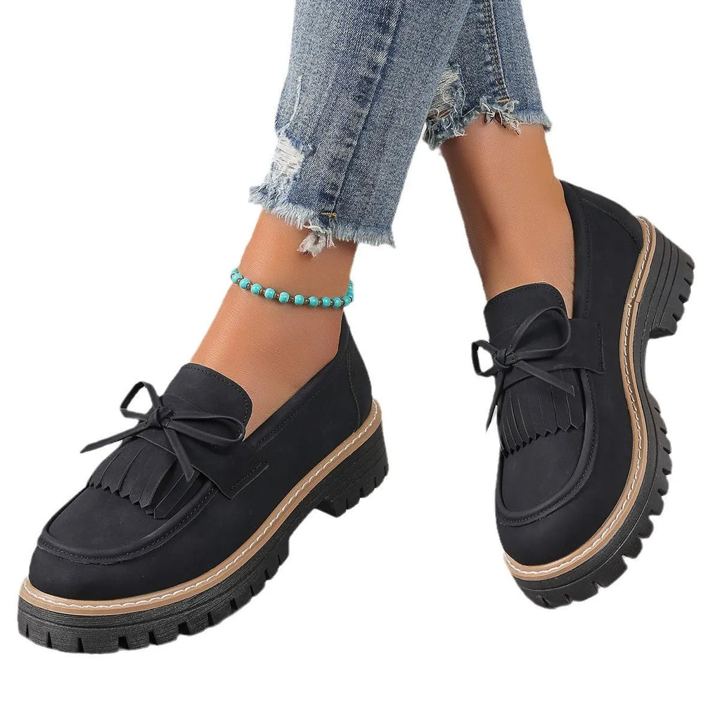 Black plus size women's loafers with tassel decoration, bowknot detail, and chunky rubber sole