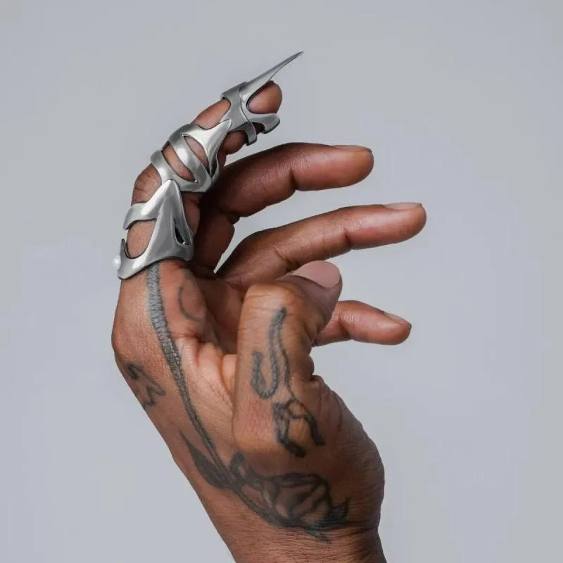 Silver punk armour finger stall ring made of alloy, shown on a finger.