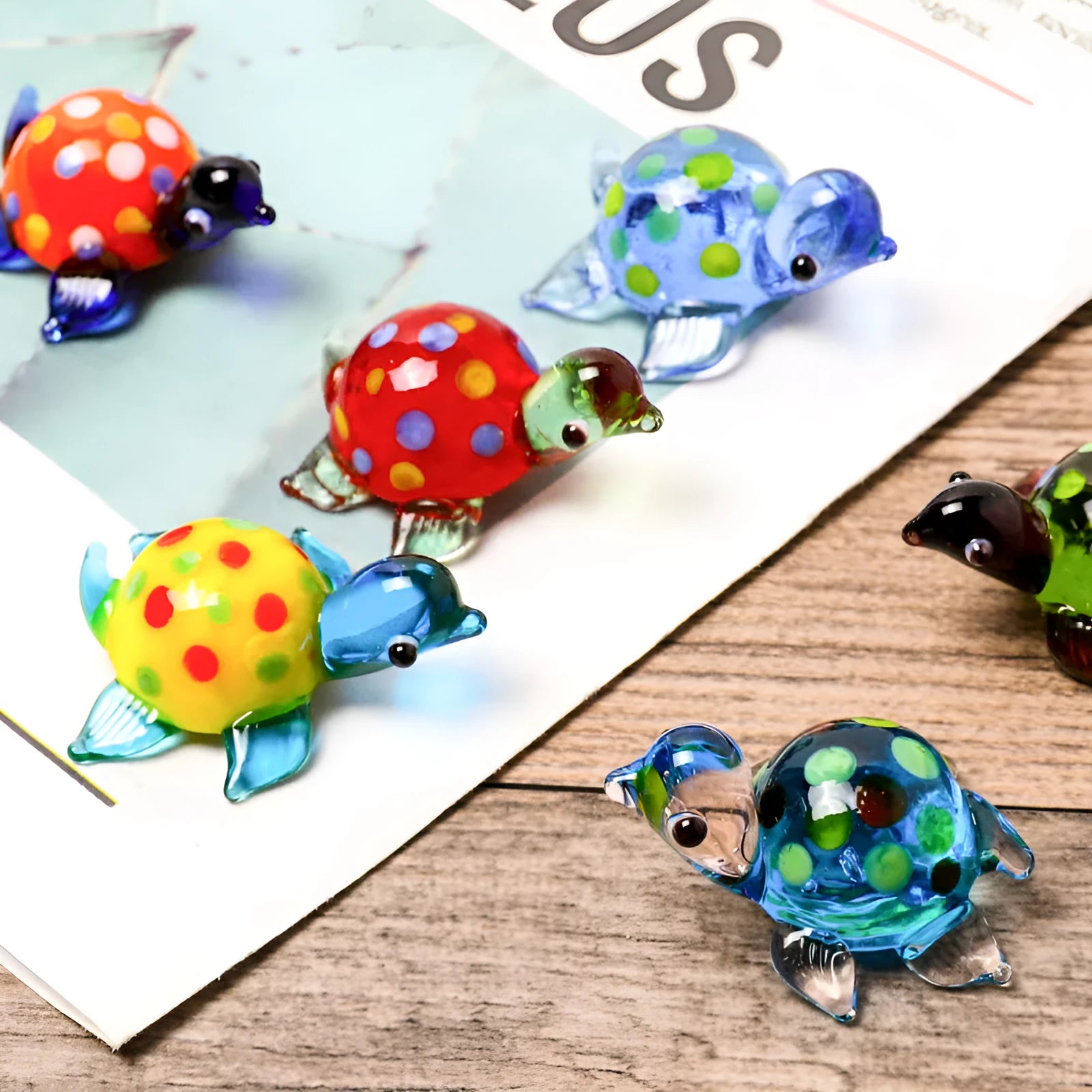 Geometric glass turtle ornament with a blue head and blue shell on a wooden desktop.