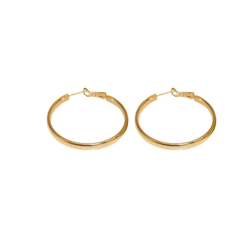 A pair of 40mm diameter metal circle earrings with a gold or silver electroplated finish.