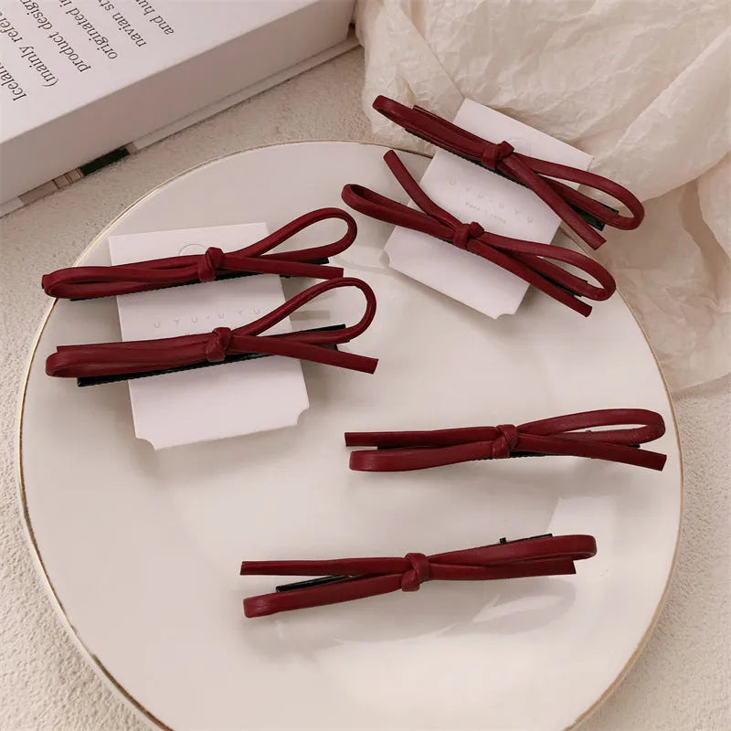 Wine red leather bow barrettes hair clips showing bow design and leather material