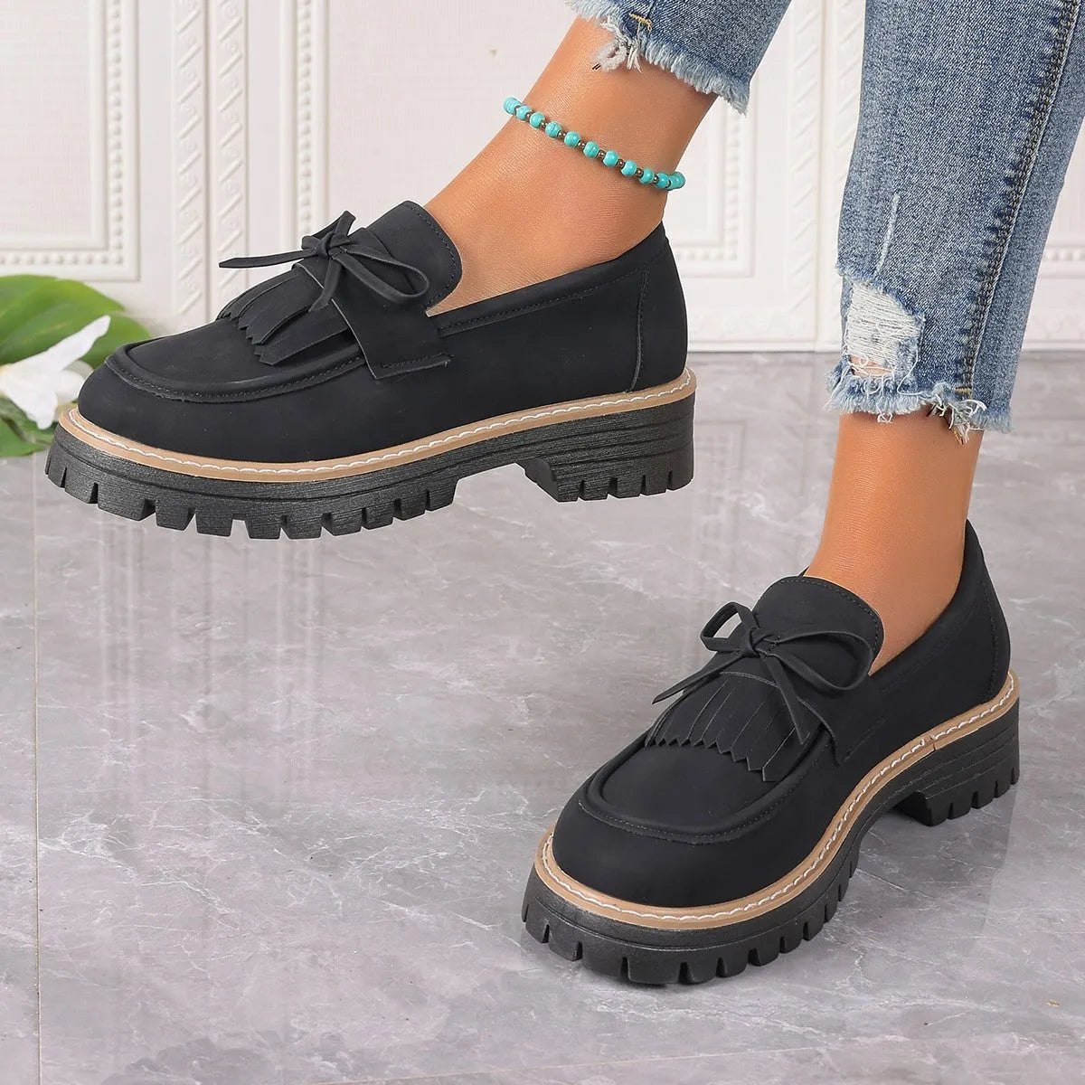 Black plus size women's loafers with tassel decoration, bowknot detail, and chunky rubber sole