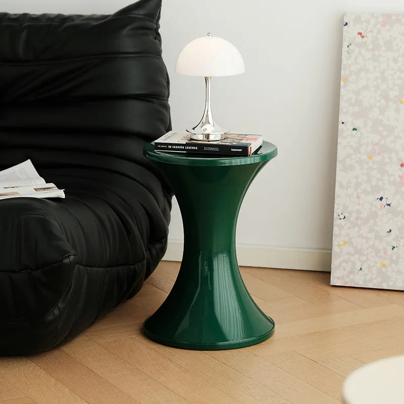 Green hourglass-shaped plastic stool for changing shoes, suitable for children and adults.