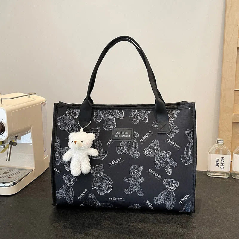 Women's black canvas tote bag with diamond pattern and shoulder strap