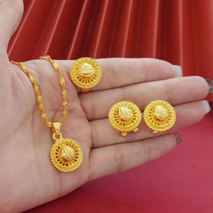 Women's three-piece jewellery set showing gold electroplated necklace with floral pendant, matching earrings, and ring with Middle Eastern design