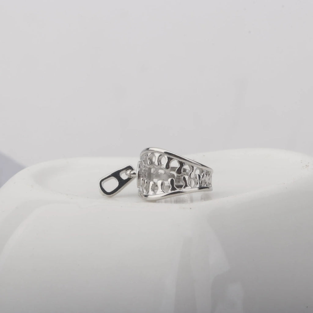 A pair of geometric bone clip earrings made from copper with linear details and an ear clip back.