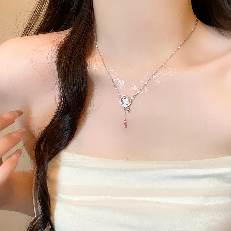 Gold tone star and moon necklace with adjustable chain on display