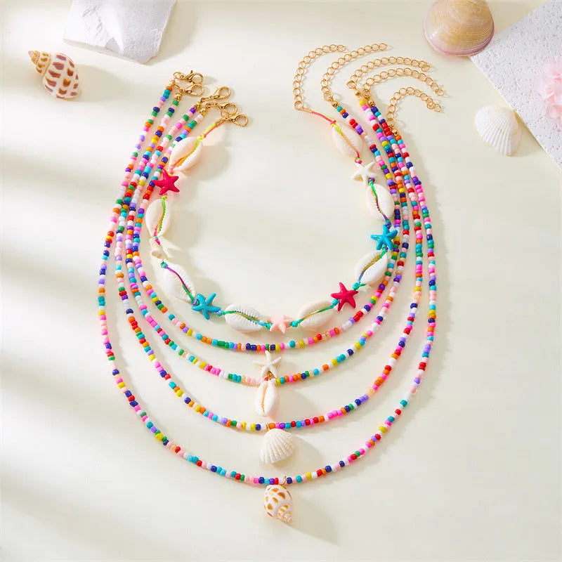 Five multi-layer beaded necklaces with starfish and shell charms in blue and colours