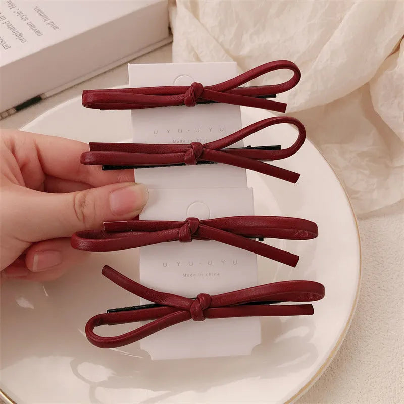 Wine red leather bow barrettes hair clips showing bow design and leather material