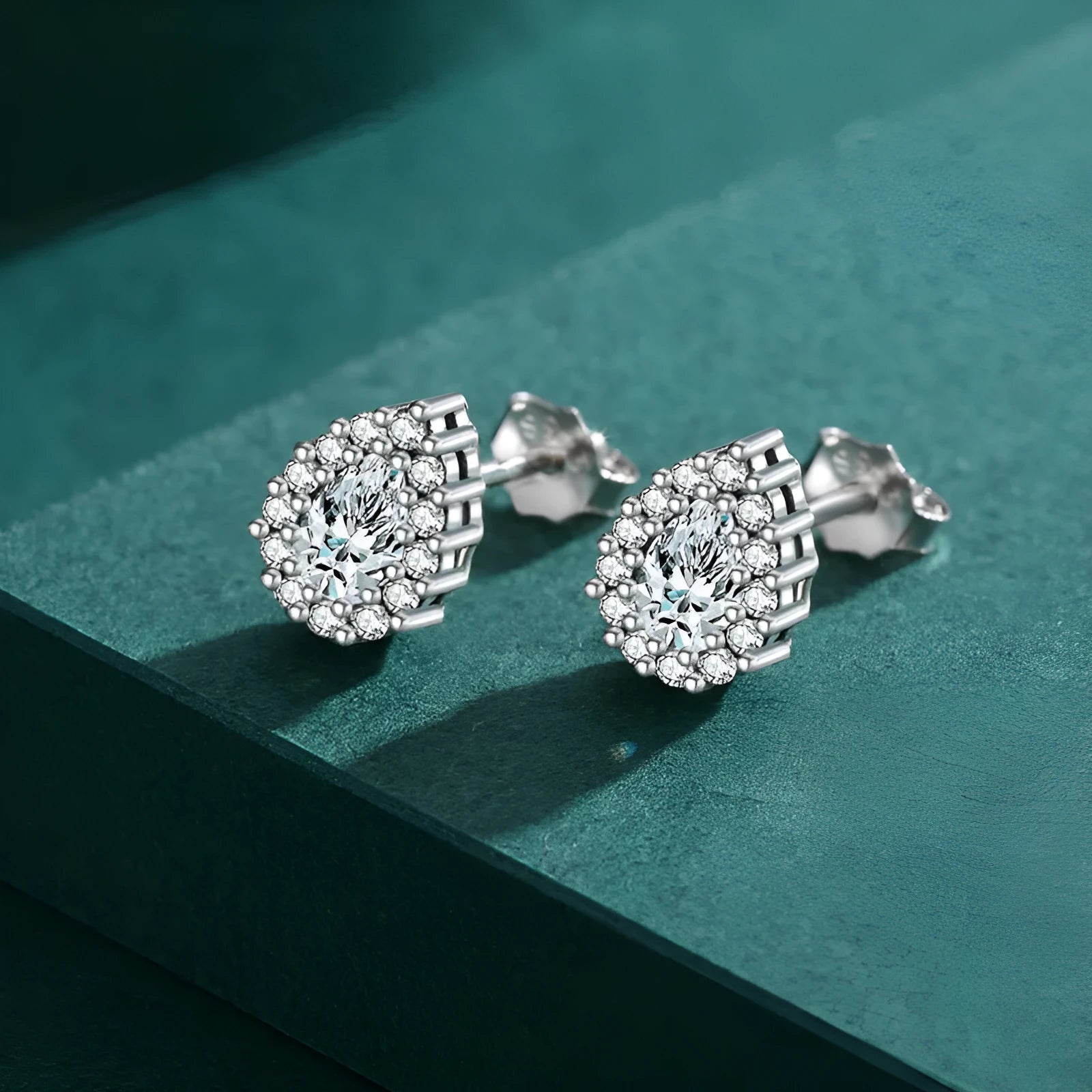 A pair of silver drop shape ear studs for women with a diamond-treated finish.