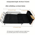 Foldable carbon steel dish drain rack holding cutlery and cups on a kitchen counter.