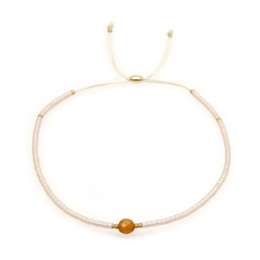 Handmade bohemian-style bracelet with semi-precious stone and colourful glass beads on a wrist.