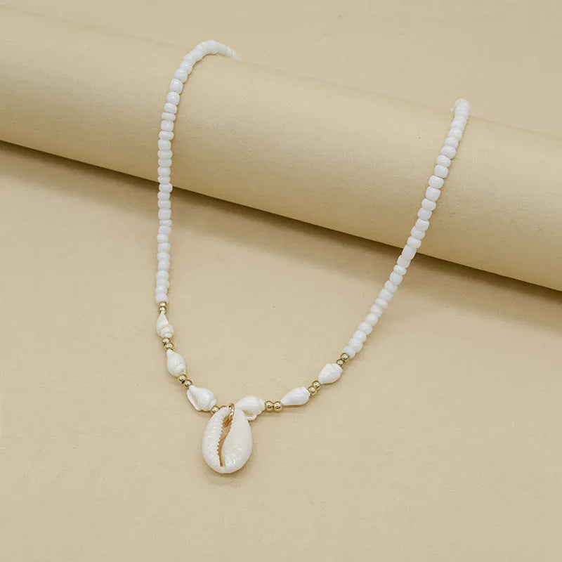 White conch shell bead necklace with mother of pearl pendant on a silver-toned electroplated chain.