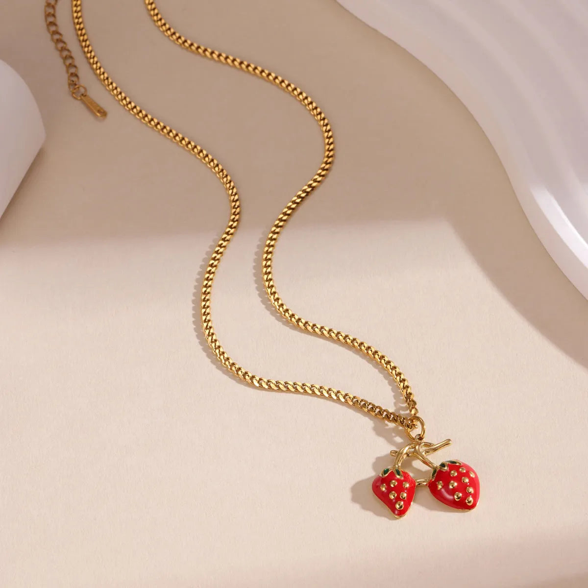 Stainless steel strawberry fruit pendant necklace on an alloy chain, shown in red and white gradient colour options.