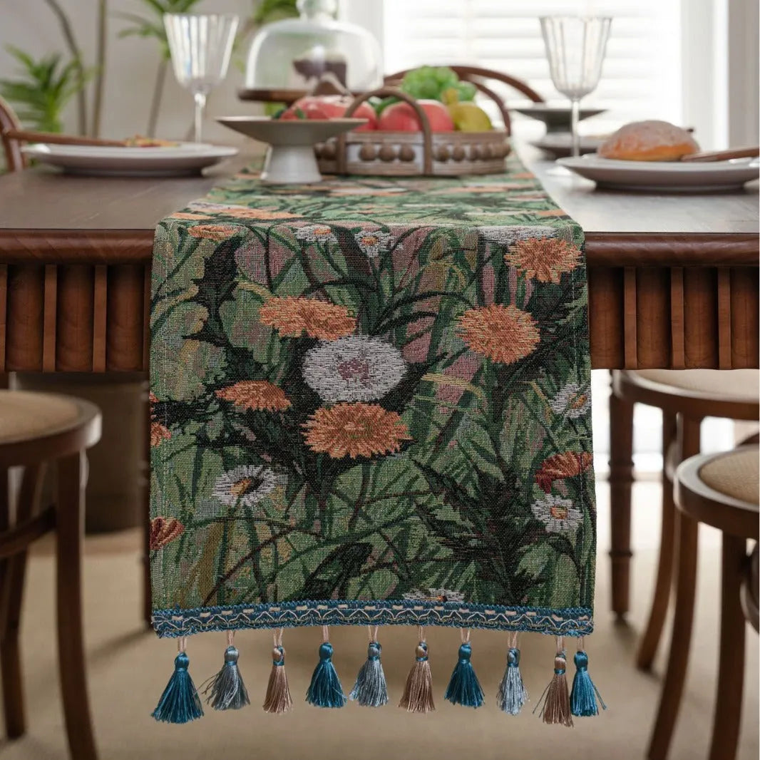 Beige jacquard fabric table runner with long tassels and a woven floral leaf pattern.