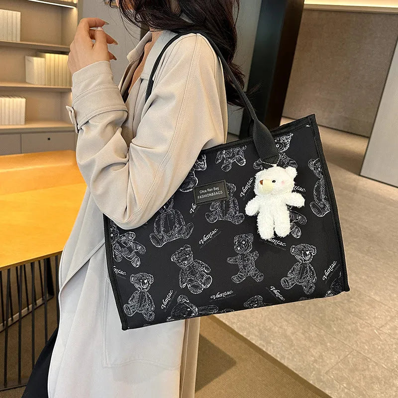 Women's black canvas tote bag with diamond pattern and shoulder strap