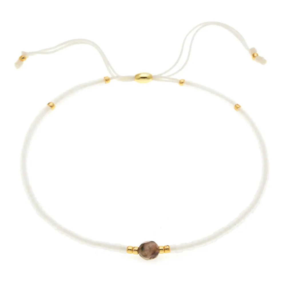 Handmade bohemian-style bracelet with semi-precious stone and colourful glass beads on a wrist.