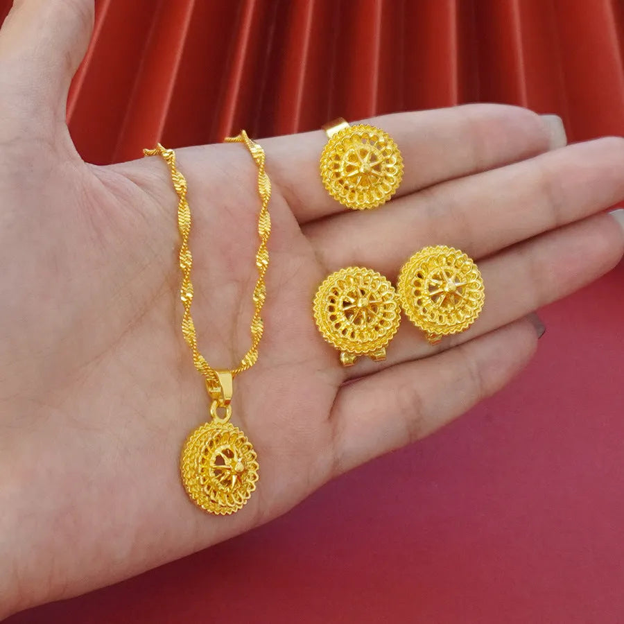 Women's three-piece jewellery set showing gold electroplated necklace with floral pendant, matching earrings, and ring with Middle Eastern design