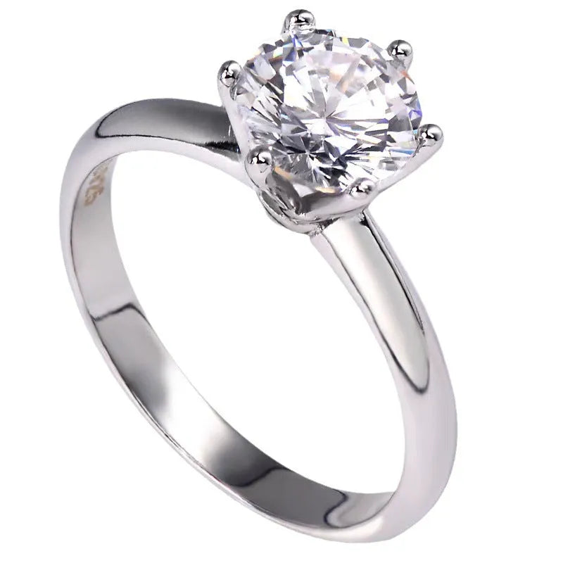 White gold plated women's ring with a geometric design and a six-claw set zircon stone.