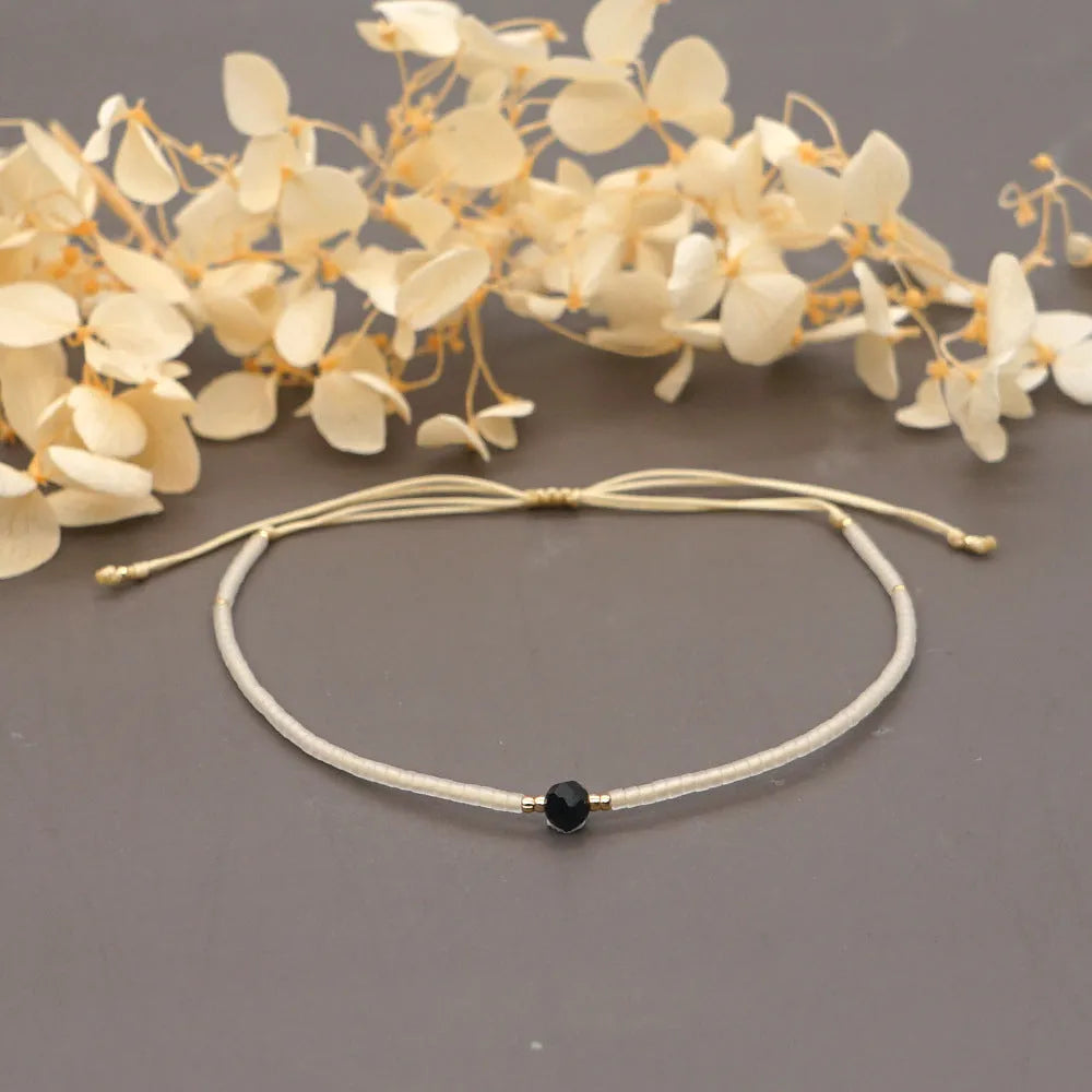 Handmade bohemian-style bracelet with semi-precious stone and colourful glass beads on a wrist.