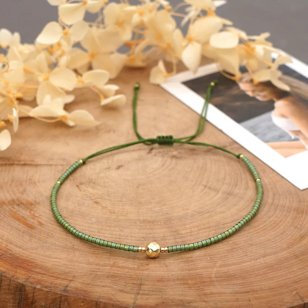 Handmade bohemian-style bracelet with semi-precious stone and colourful glass beads on a wrist.