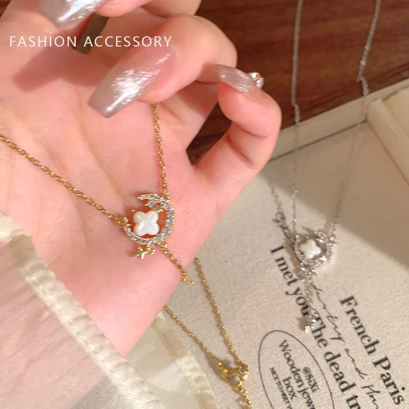Gold tone star and moon necklace with adjustable chain on display