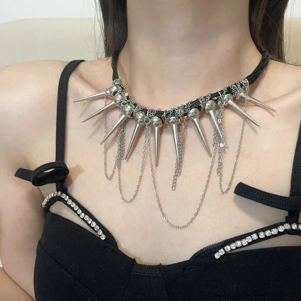 Women's leather necklace with round beads, a winding tassel, and silver point rivets on a casual outfit.