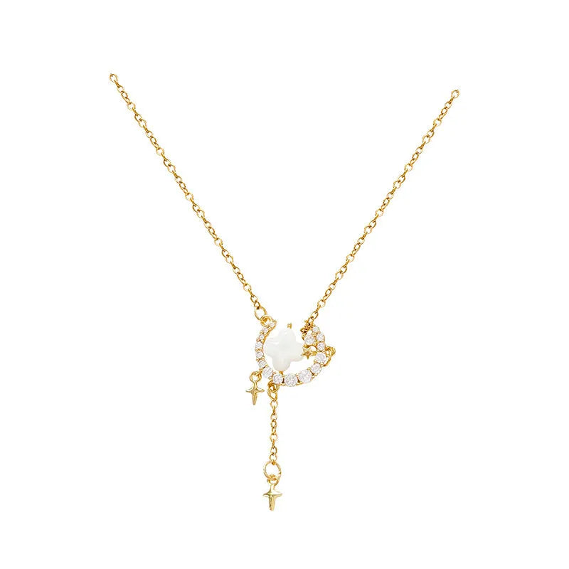 Gold tone star and moon necklace with adjustable chain on display