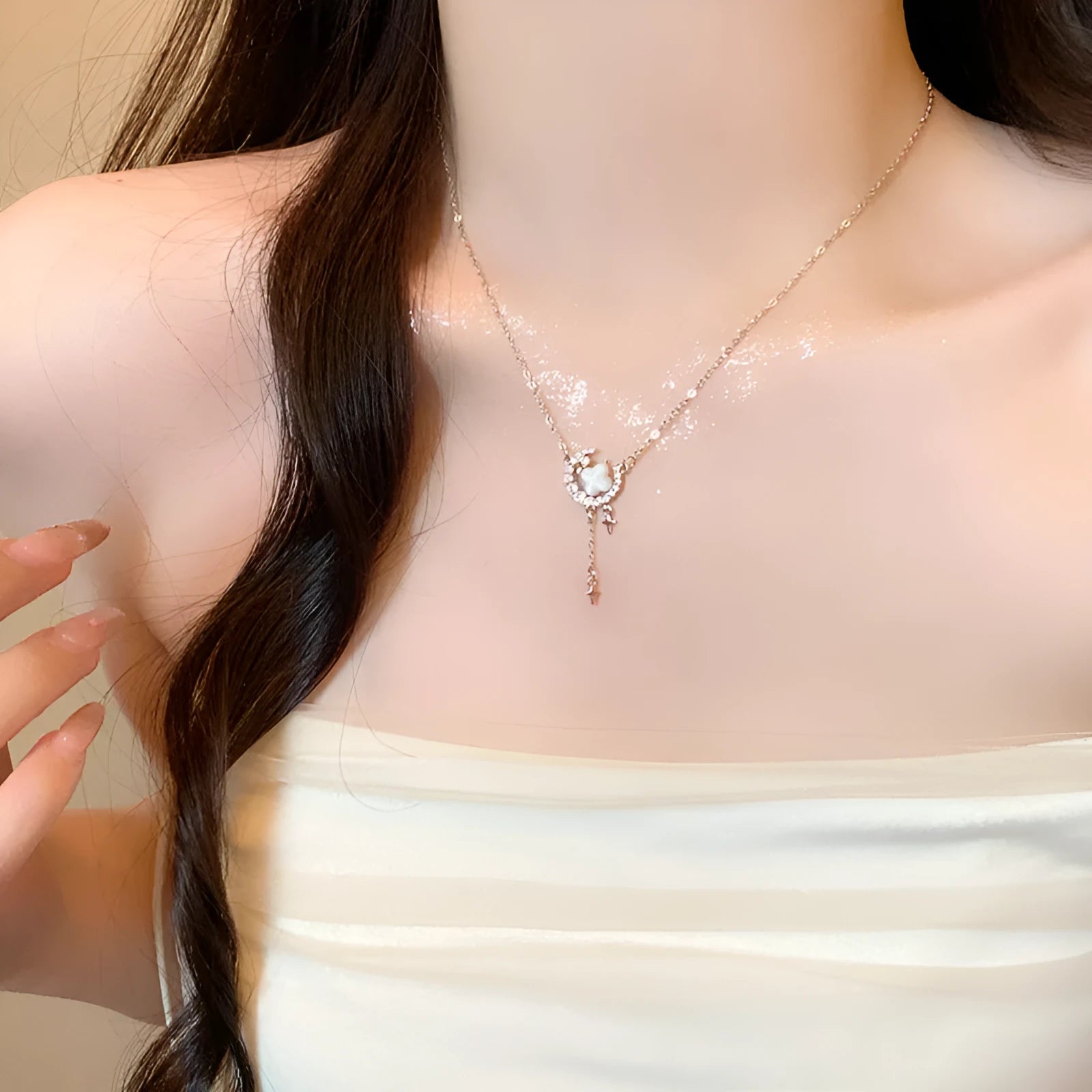 Gold tone star and moon necklace with adjustable chain on display
