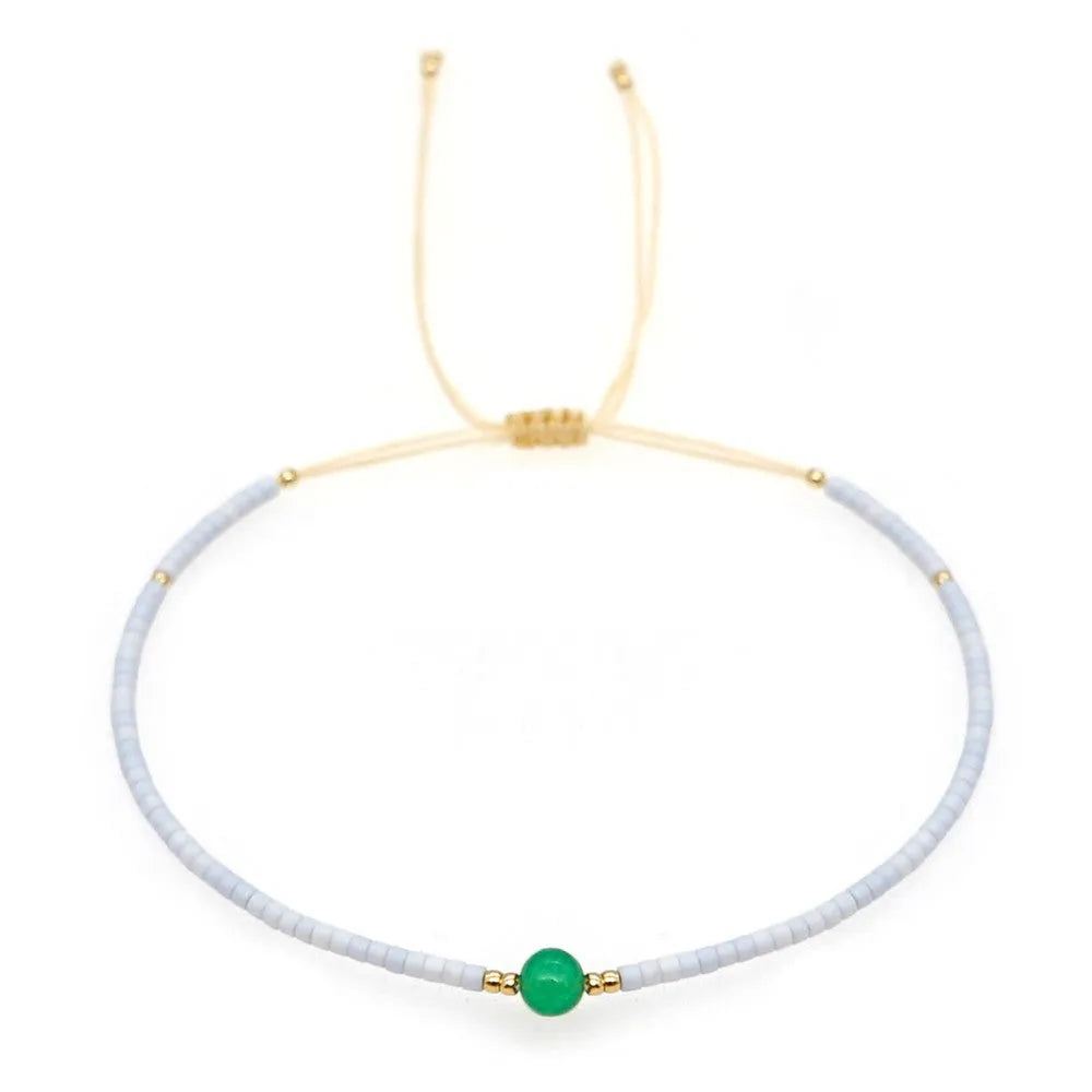 Handmade bohemian-style bracelet with semi-precious stone and colourful glass beads on a wrist.