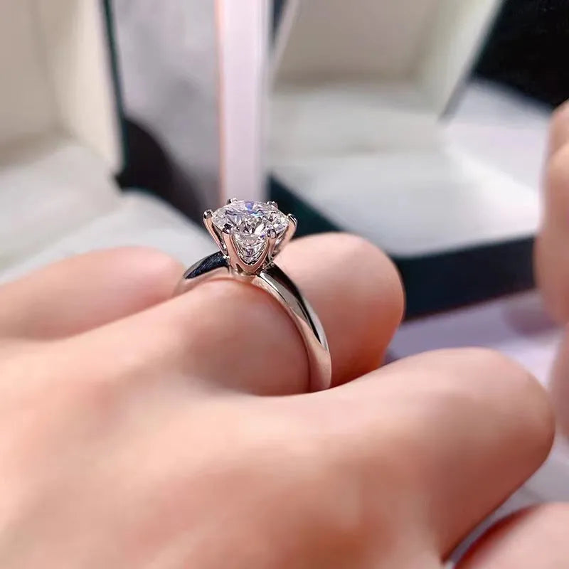 White gold plated women's ring with a geometric design and a six-claw set zircon stone.