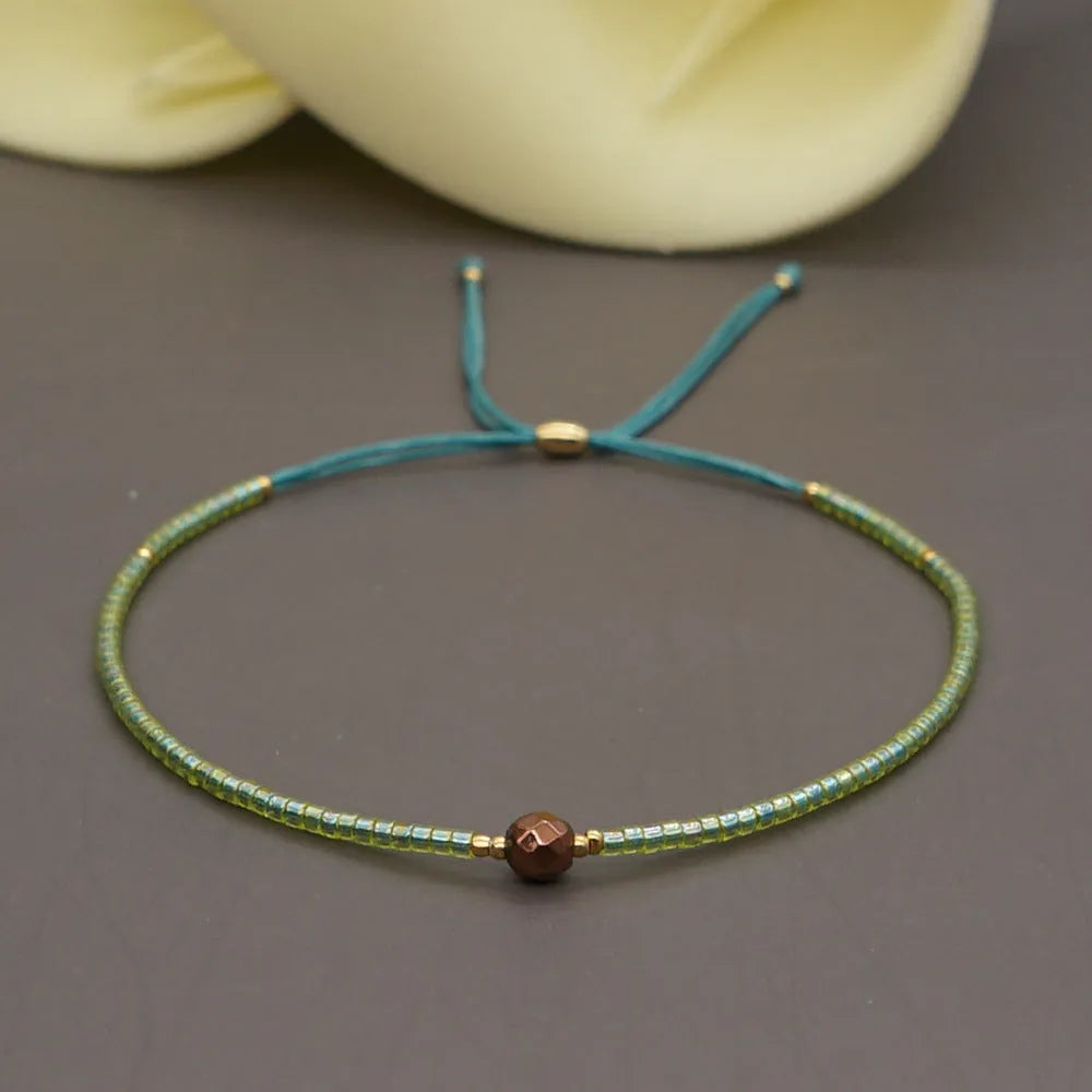 Handmade bohemian-style bracelet with semi-precious stone and colourful glass beads on a wrist.