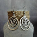 Silver geometric spiral earrings with distressed finish, measuring 2.6cm wide by 5cm long