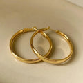 A pair of 40mm diameter metal circle earrings with a gold or silver electroplated finish.